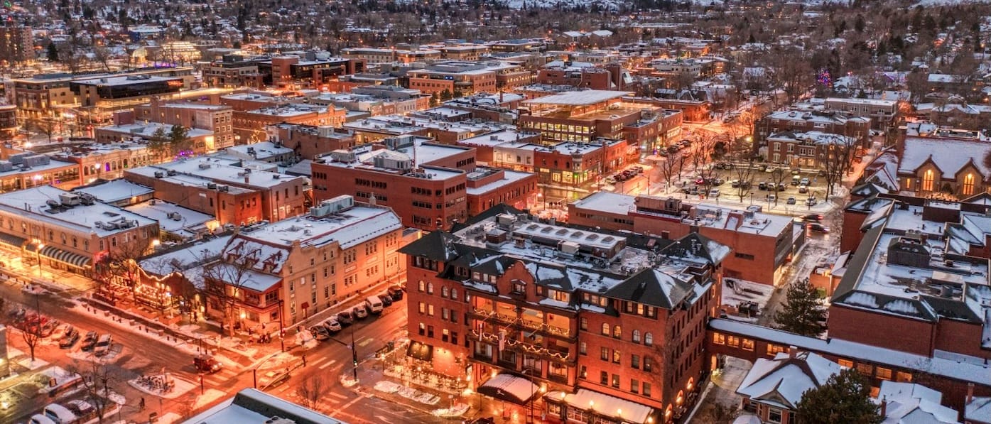 Aerial View of Boulder, Colorado in Wintertime. Historic Brick Buildings with Snow-Covered Tops Dominate the Image. 