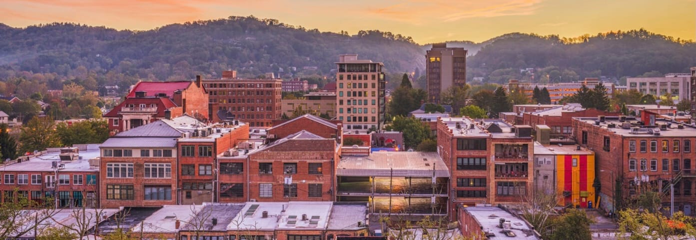 Aerial View of Asheville, North Carolina. Foreground is the warehouse district in the foreground and beautiful hills in the background. 