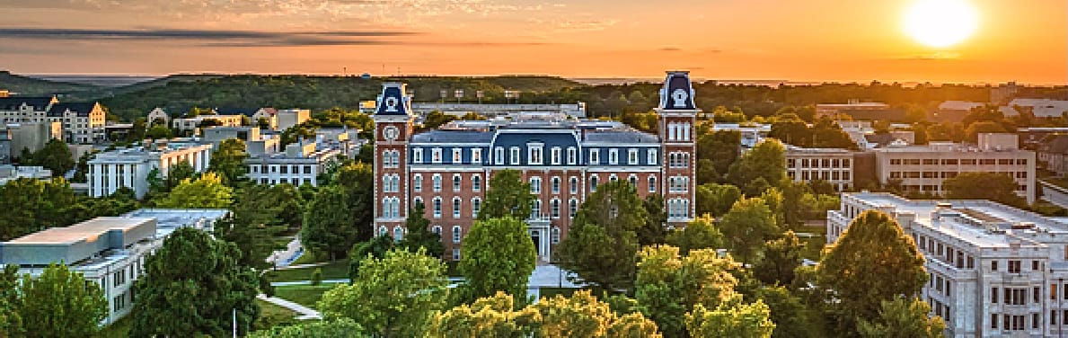 Aerial View of Fayetteville, Arkansas. University of Arkansas Campus is Center of Image with sun rising in the background. 