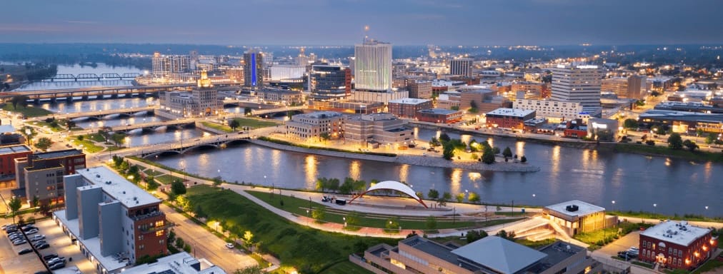 Aerial View of Cedar Rapids, Iowa at dusk. The Cedar River runs though the center of the image with five bridges crossing the river into downtown Cedar Rapids in the background. 