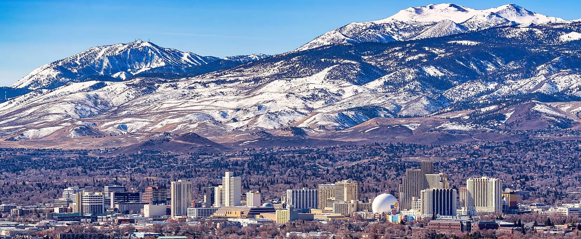 Reno Nevada pictured beautifully with the snow-covered Sierra Mountains looming in the background. 
