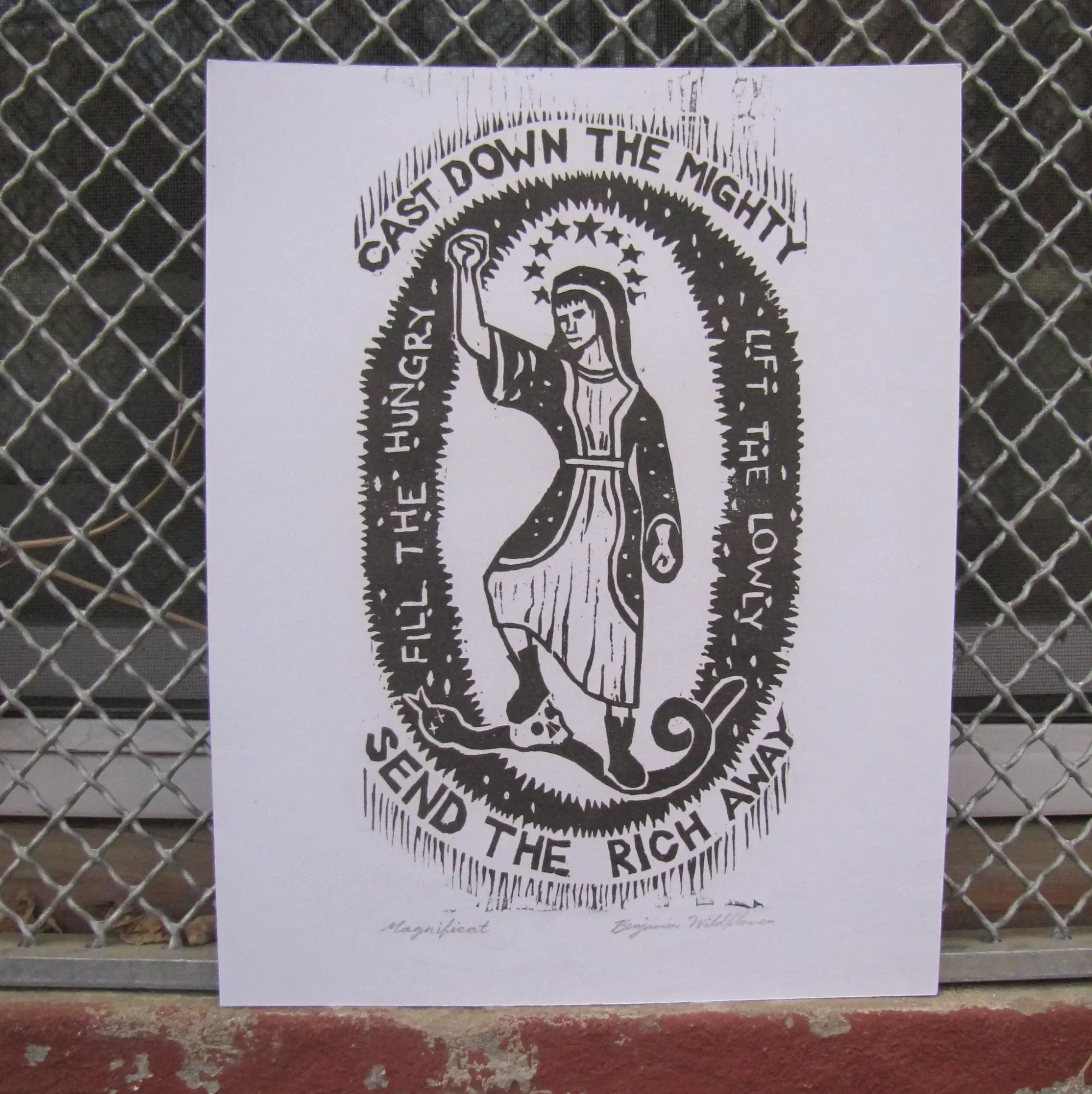 A print, “Magnificat” by Ben Wildflower showing Jesus with the words Cast Down The Mighty and Send The Rich Away