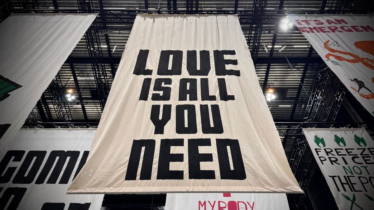 A banner reading LOVE IS ALL YOU NEED at The Fête of Britain in Manchester February 2024