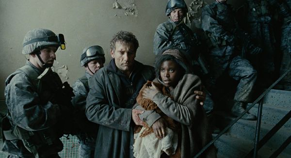 A scene from the film Children of Men by Alfonso Cuarón. A young mother holds a child, having been captured by soldiers