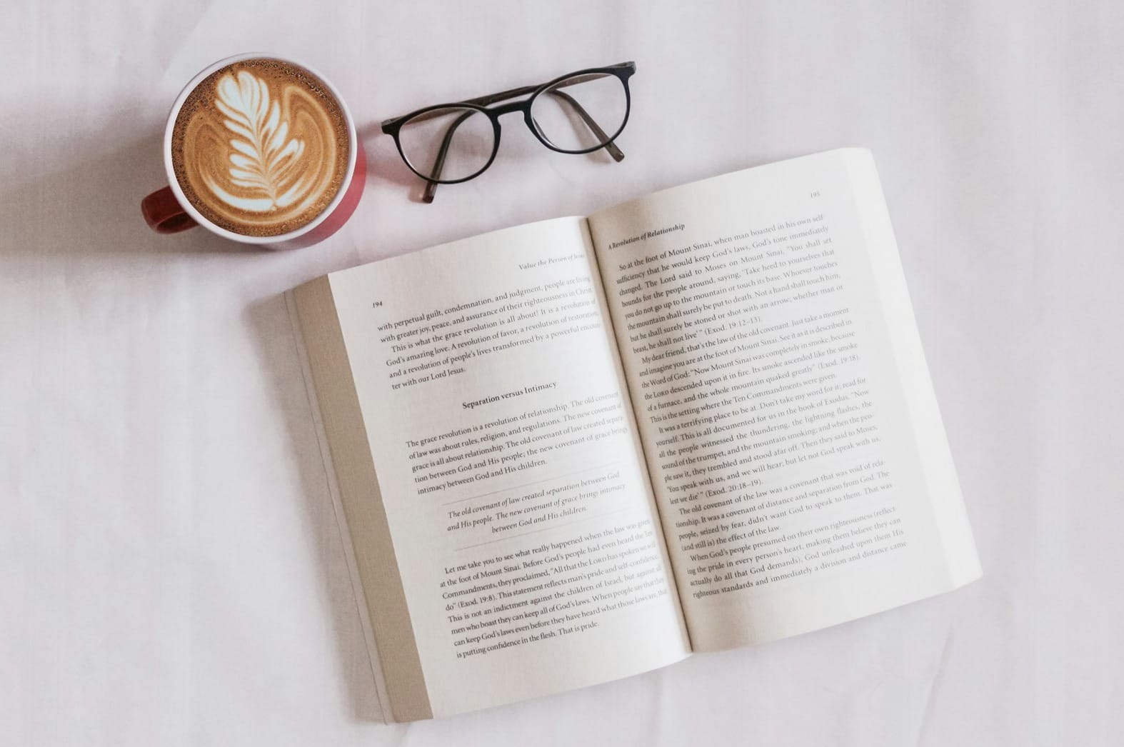 book near eyeglasses and cappuccino