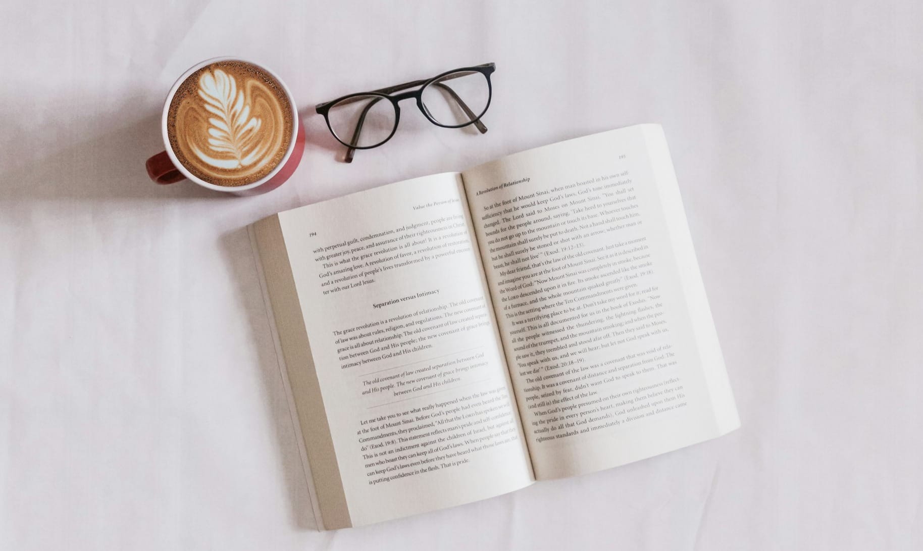 book near eyeglasses and cappuccino