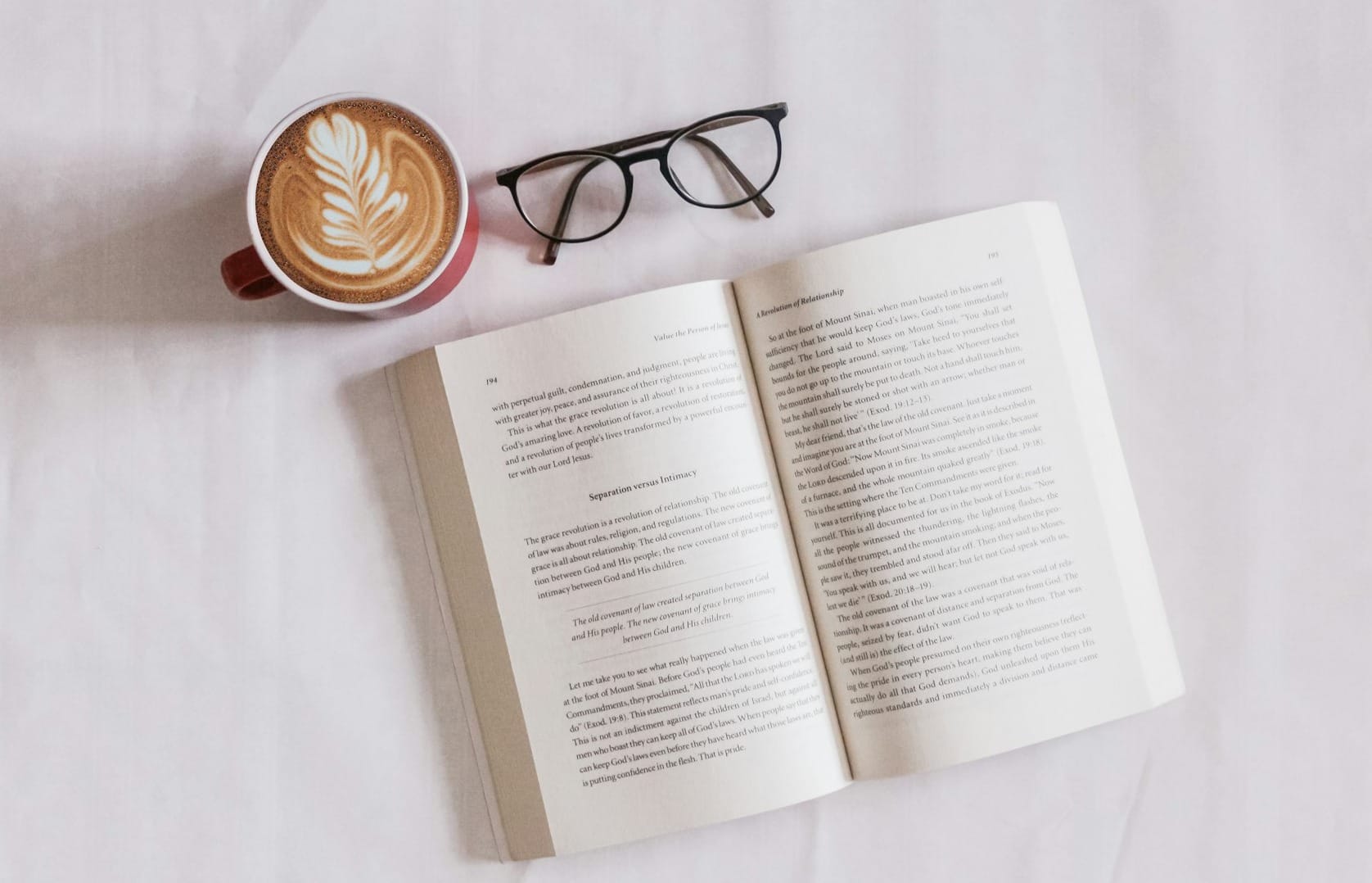 book near eyeglasses and cappuccino
