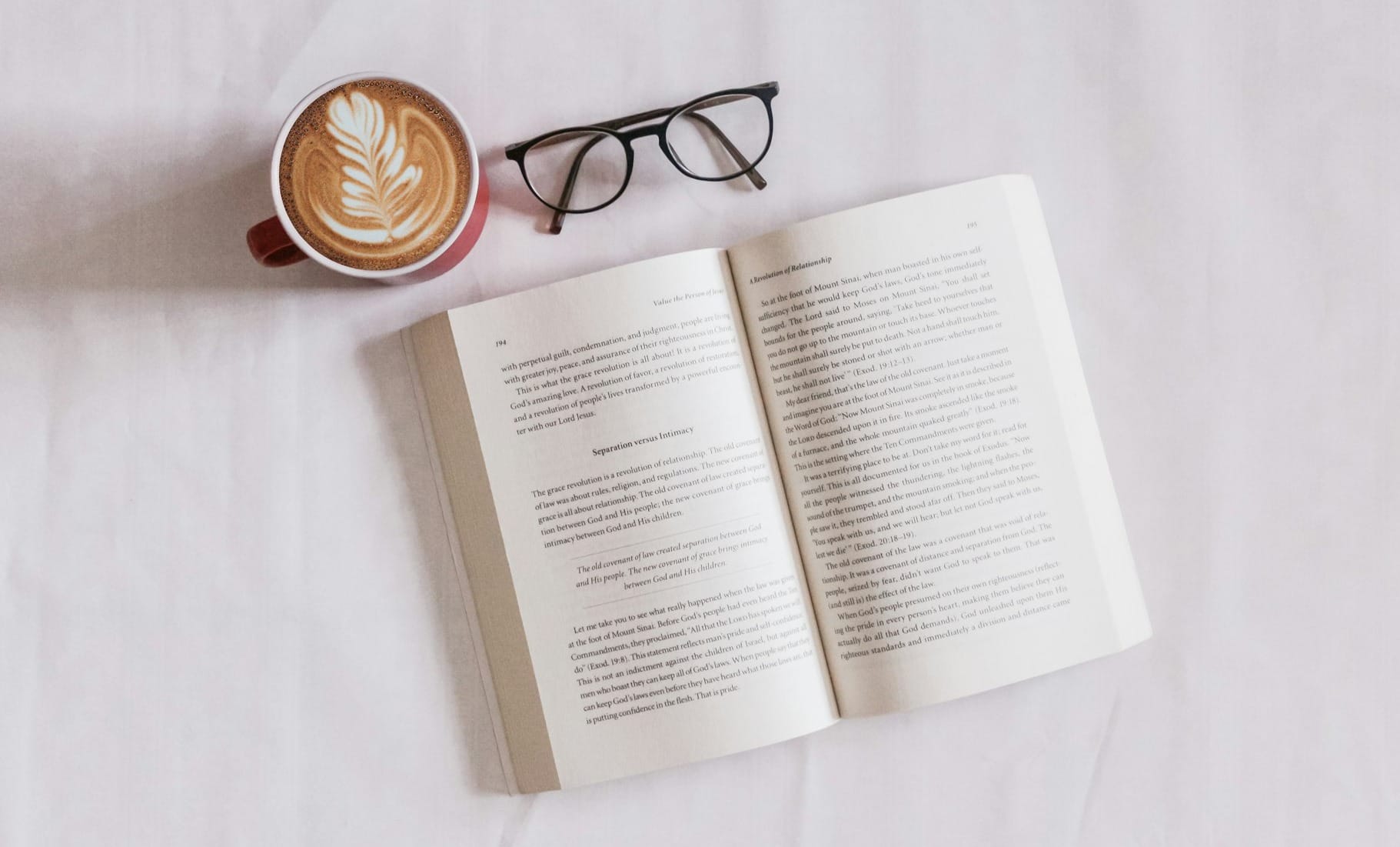 book near eyeglasses and cappuccino
