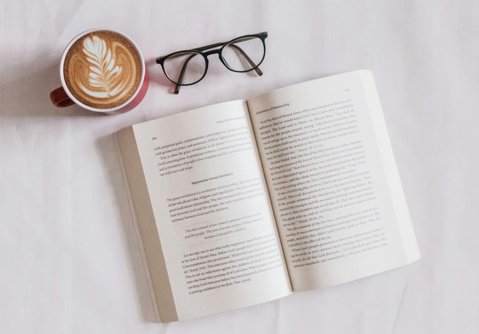 book near eyeglasses and cappuccino