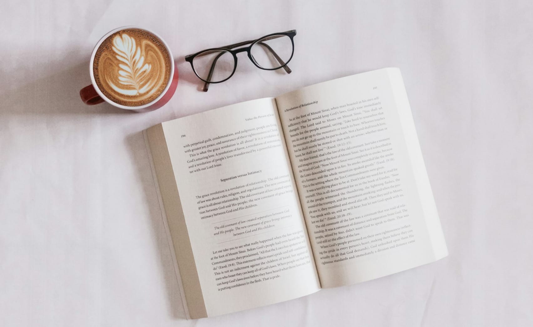 book near eyeglasses and cappuccino