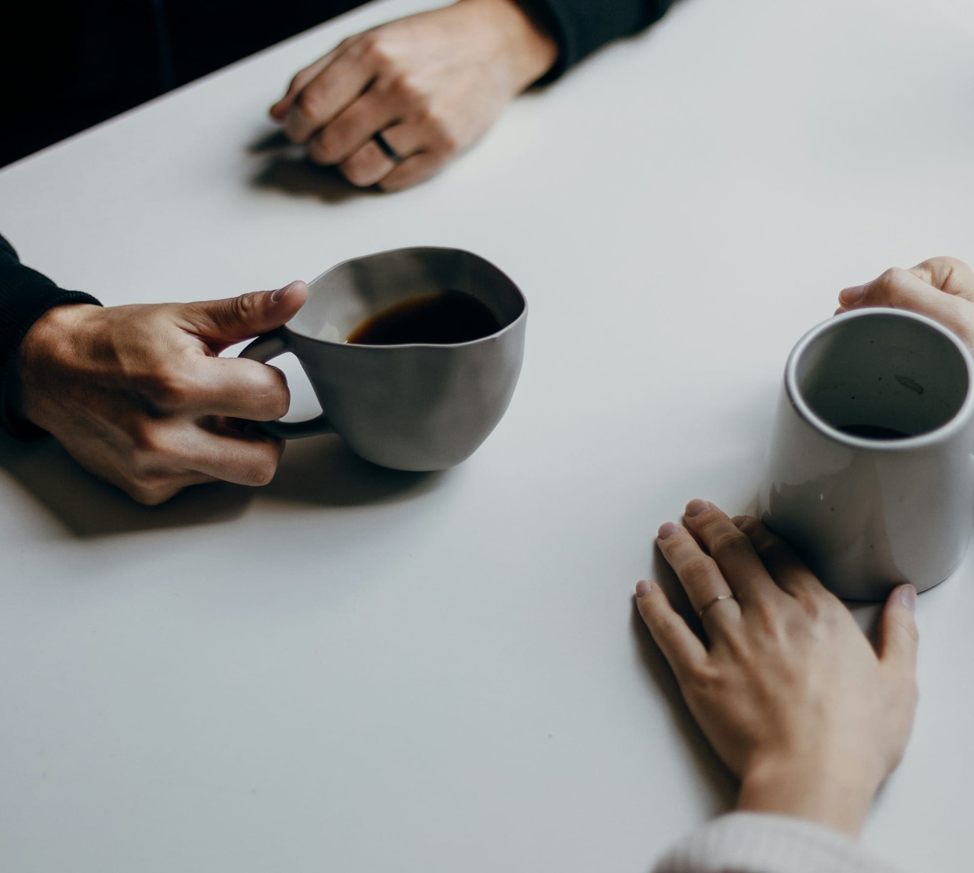 a couple of people sitting at a table with cups of coffee