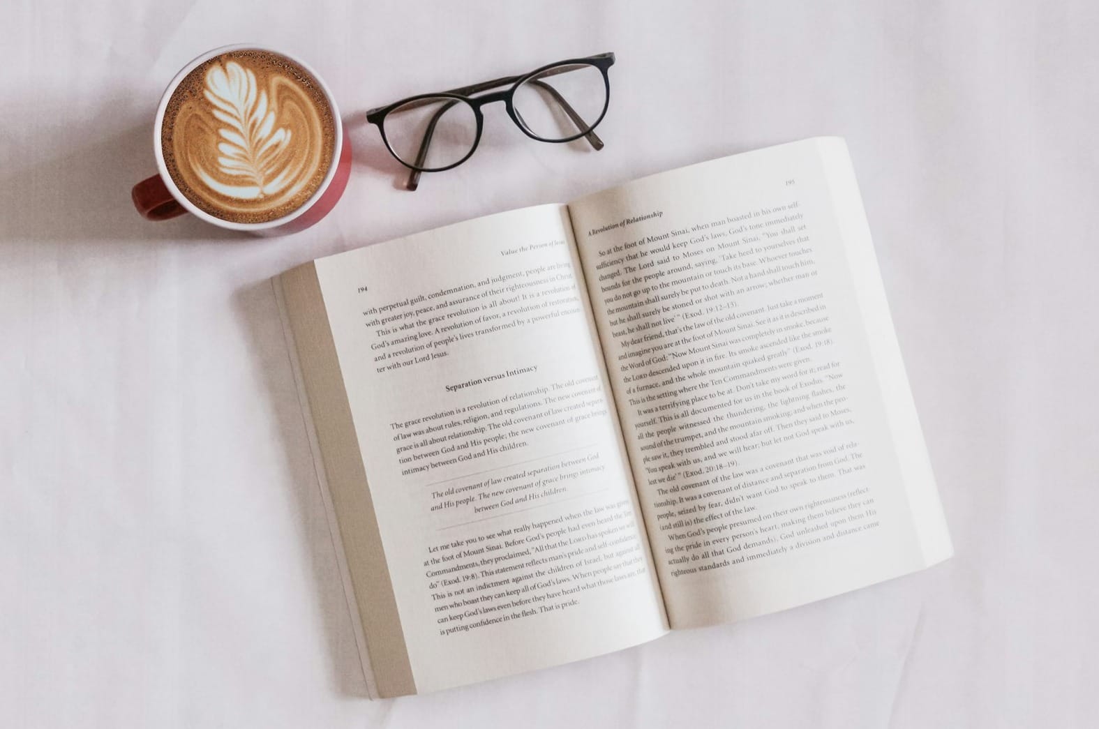 book near eyeglasses and cappuccino