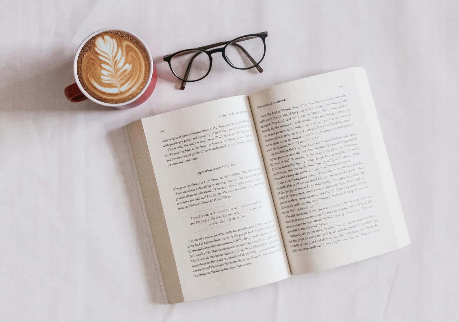 book near eyeglasses and cappuccino