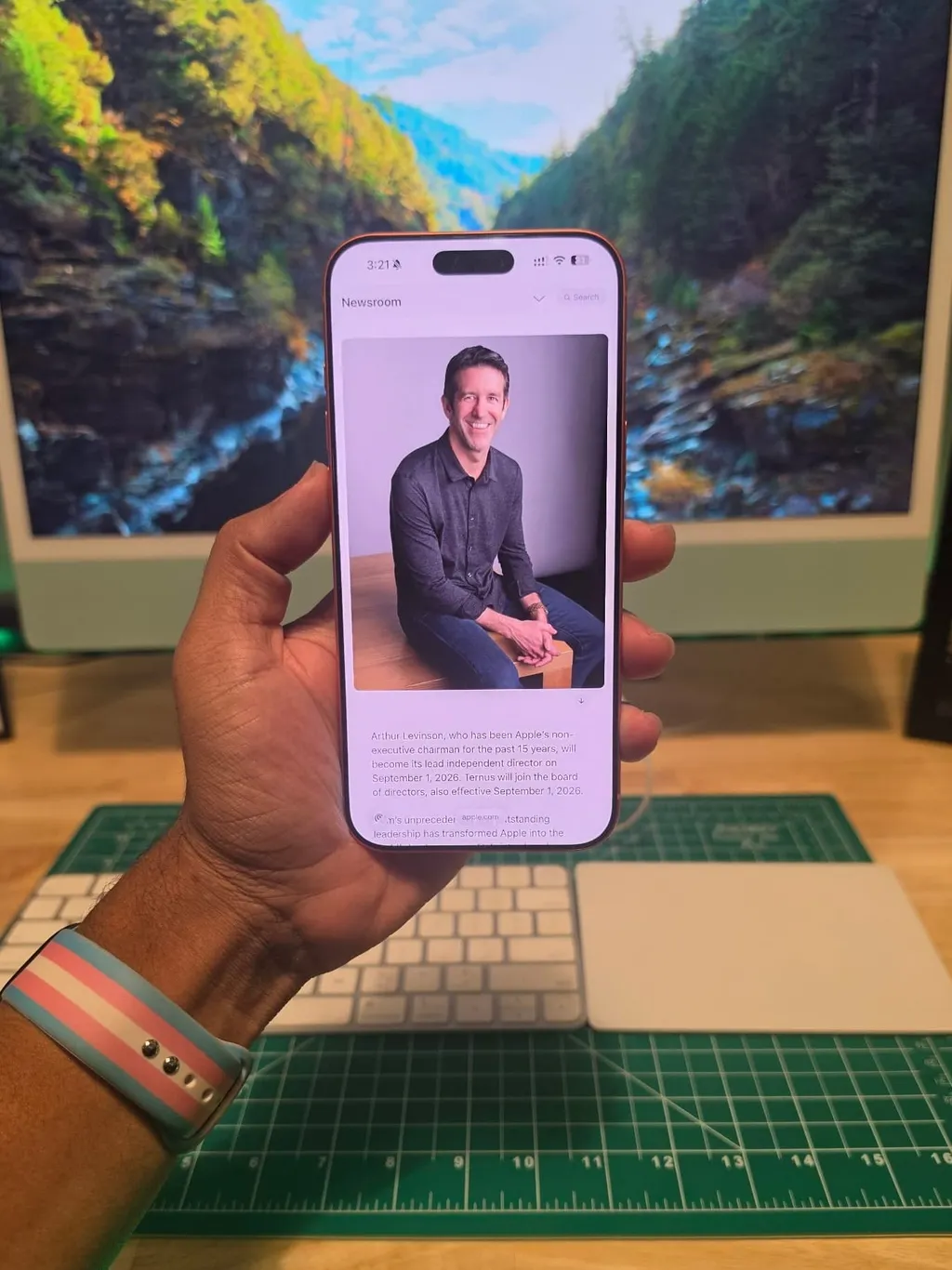 Photo of upcoming Apple CEO John Ternus on an iPhone 17 Pro Max in the visionaryPass Office with a green iMac in the background