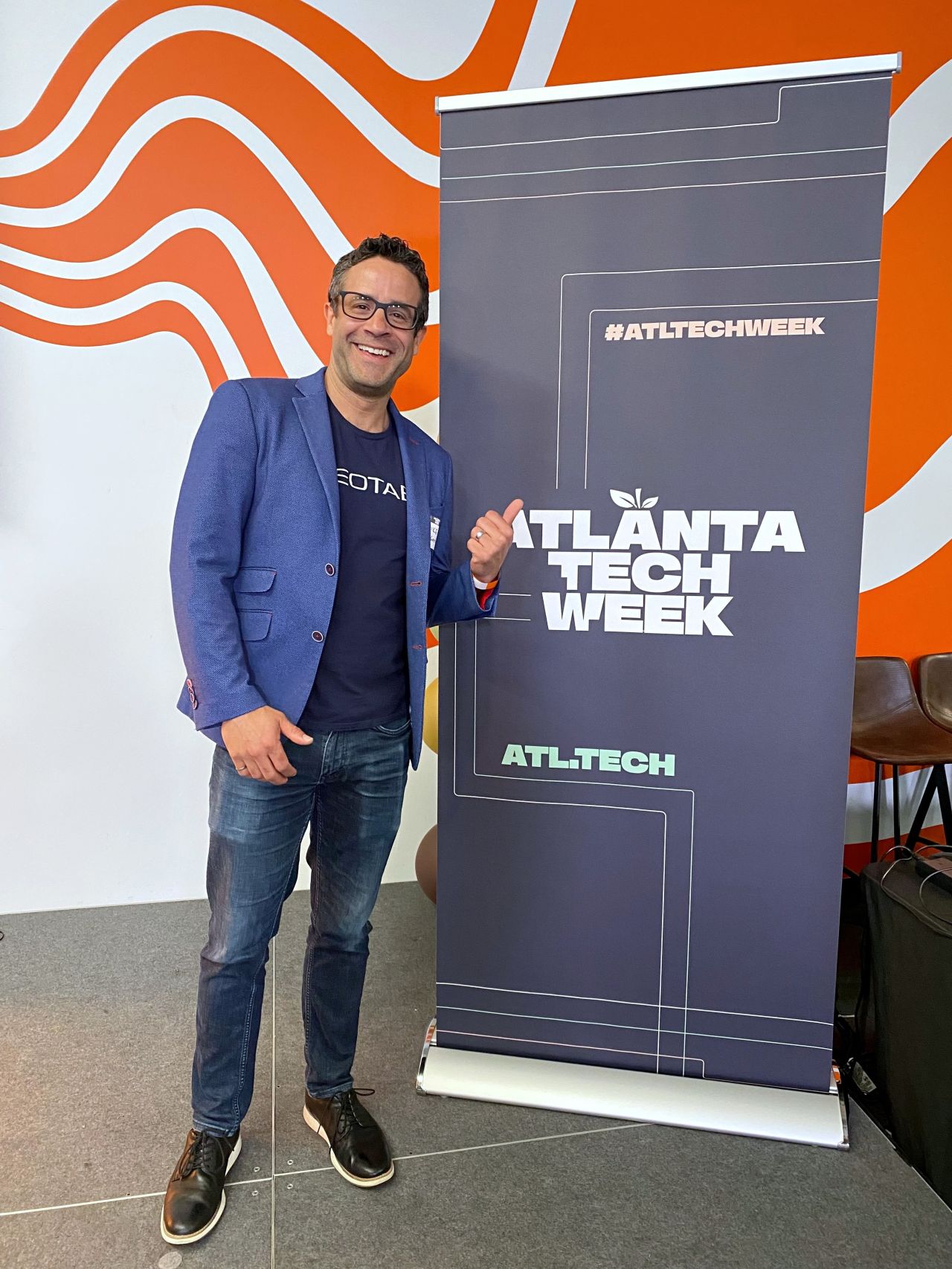 Mike Branch of Geotab in front of an Atlanta Tech Week poster 