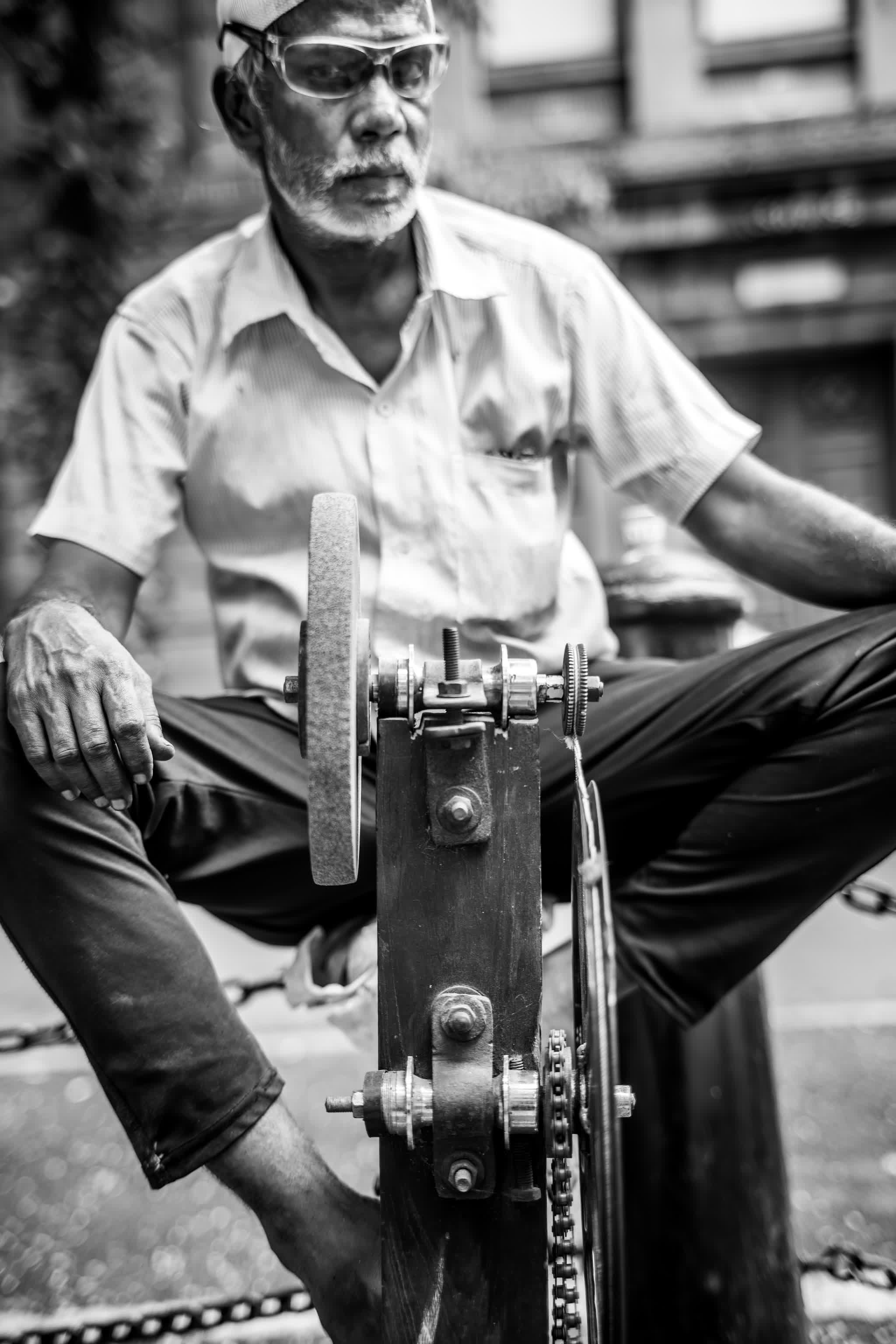 Portrait of a knife-sharpener at his pedal wheel