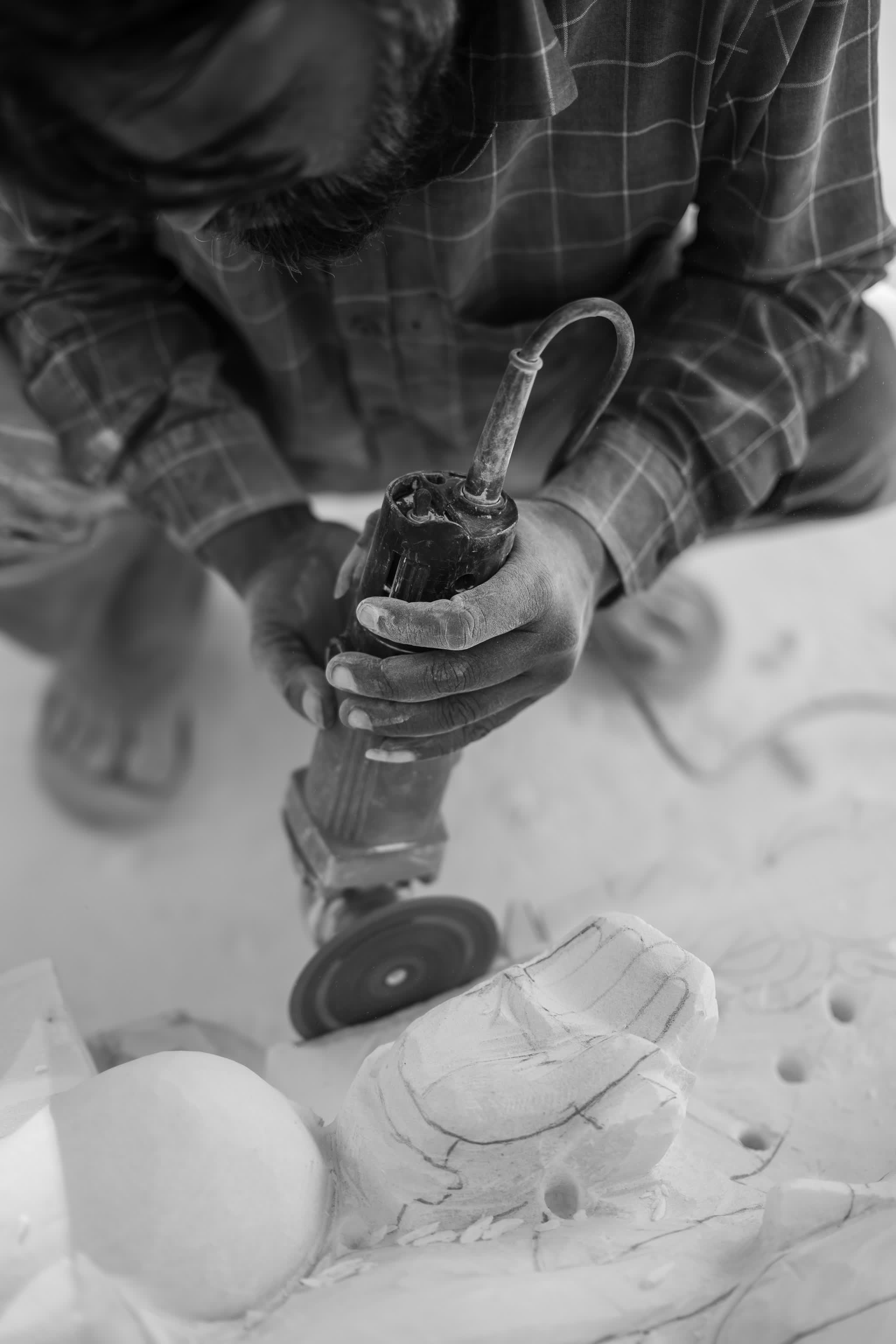A sculptor's hands at work on marble