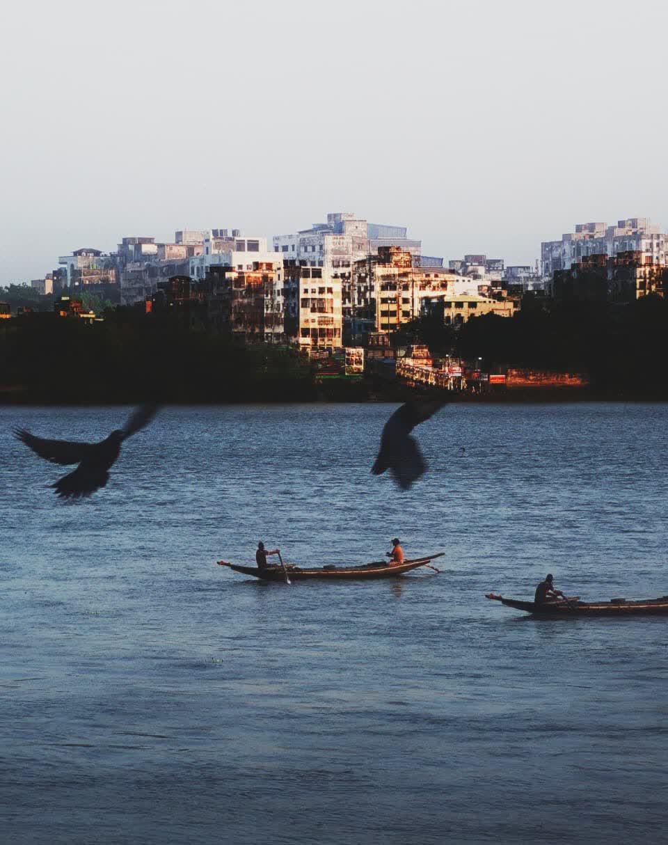 Balance — boats on the river beneath the city skyline at dusk