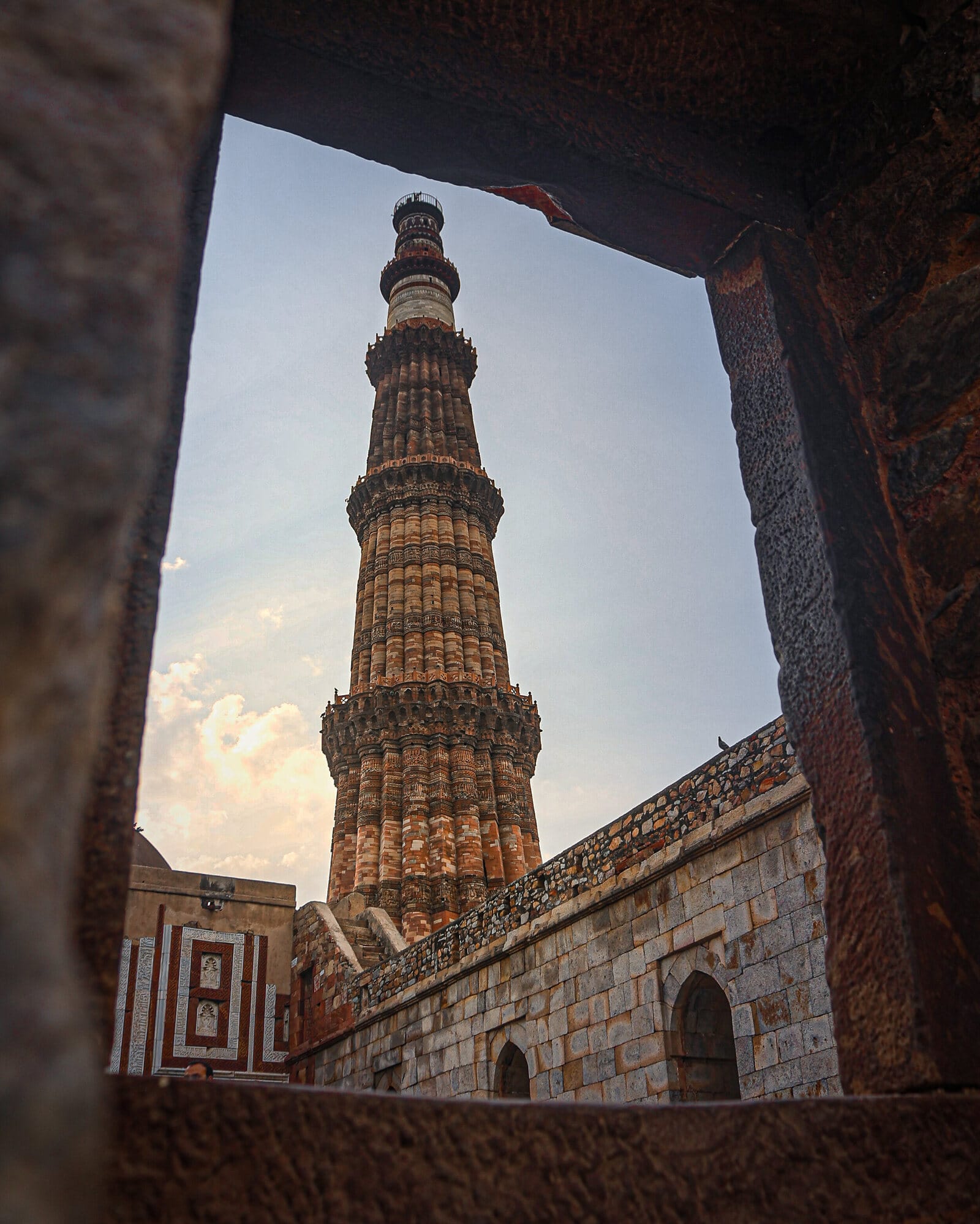 Qutub Minar framed through a doorway at sunset