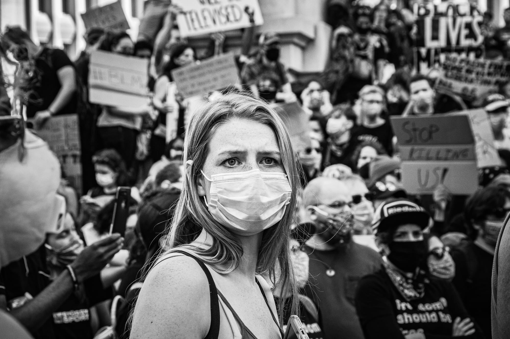 Woman in a surgical mask participating in a public protest