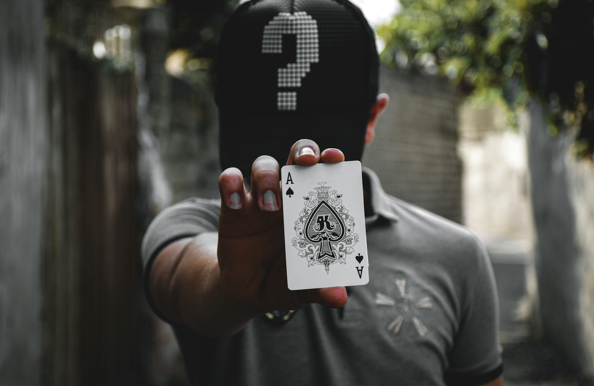 man in gray crew neck t-shirt holding ace of spade playing card