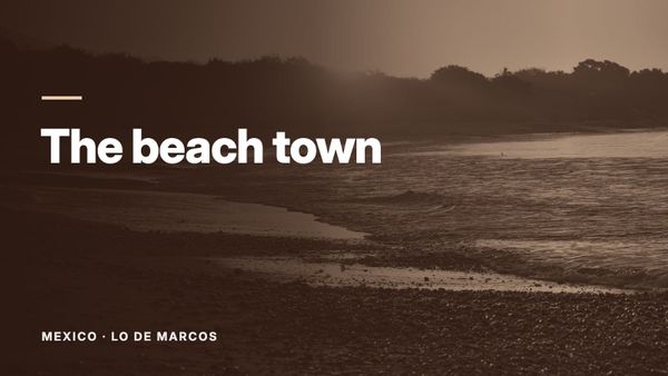 Sunset over a beach, with the low sun reflecting on wet sand. Text: “The beach town”, Mexico: Lo de Marcos.
