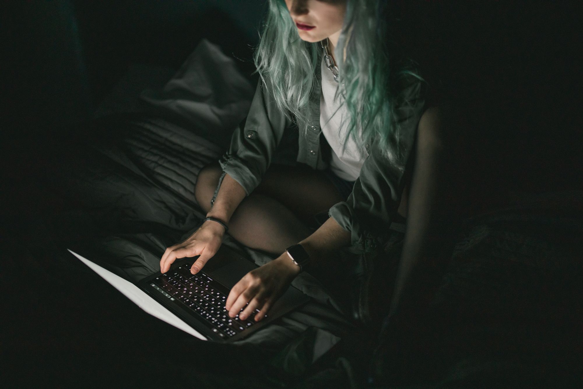 A young woman at a laptop at night. Photo by cottonbro studio via Pexels