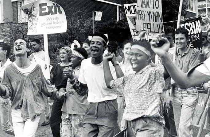 Marchers laughing and holding signs at a lesbian and gay pride march