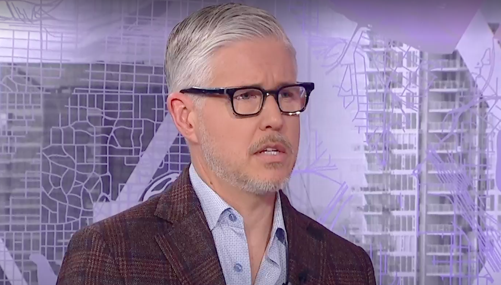 man in tweed suit jacket with skeptical look on his face