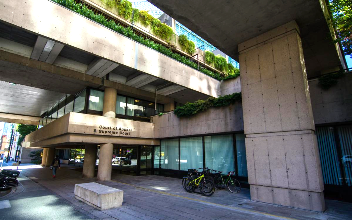 A concrete building with plants growing around it and a sign saying "Court of Appeal & Supreme Court"