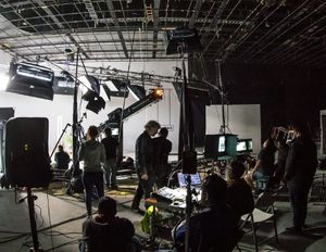 a group of people filming something on a set being managed by a manager