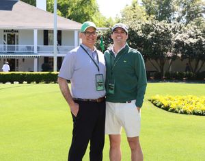 Greg Chambers and his son at the 2026 Masters in front of the big house