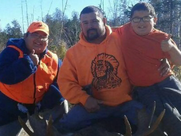 Three indigenous people of various ages all in orange shirts
