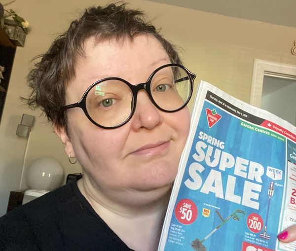 Yours truly, unshowered on a sunny Saturday morning in my living room, holding the latest Canadian Tire flier