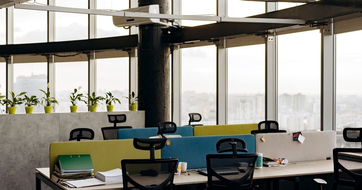 Open-plan office with desks beside floor-to-ceiling windows