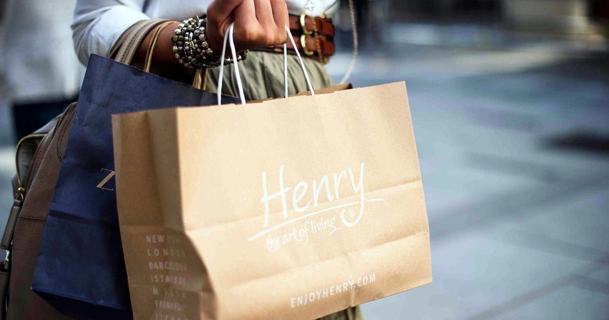 Person holding brown paper shopping bags