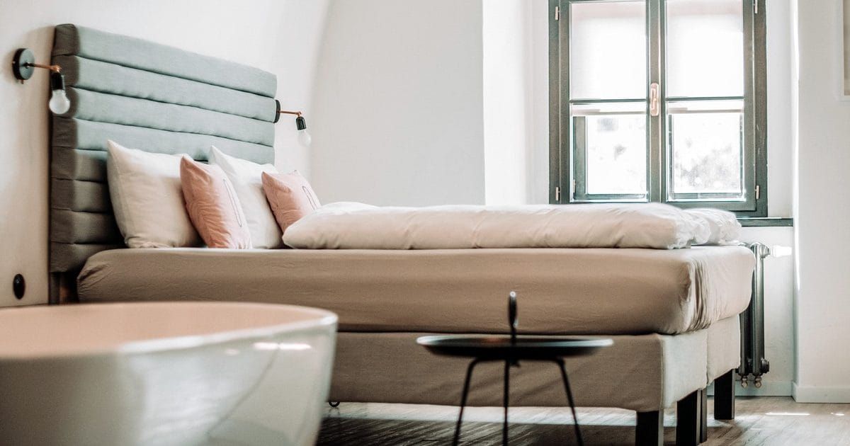 Hotel room with a bed beside a bright window