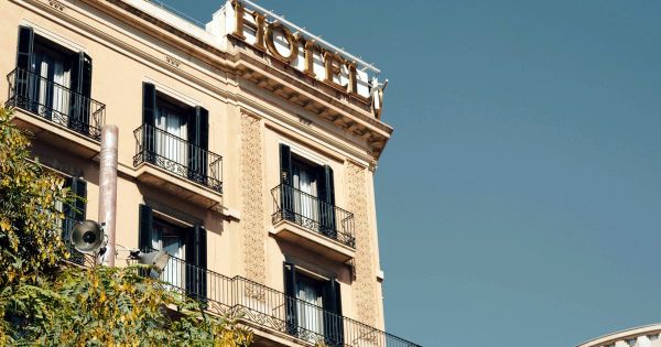 Classic hotel building facade with balconies and a HOTEL sign