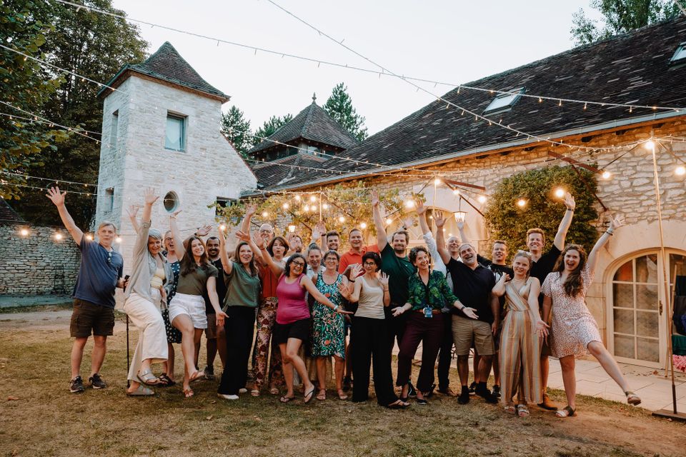 A group of facilitators outside a castle celebrating the end of a week
