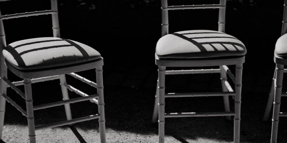 Image description: A black and white photo with two unoccupied chairs placed next to each other