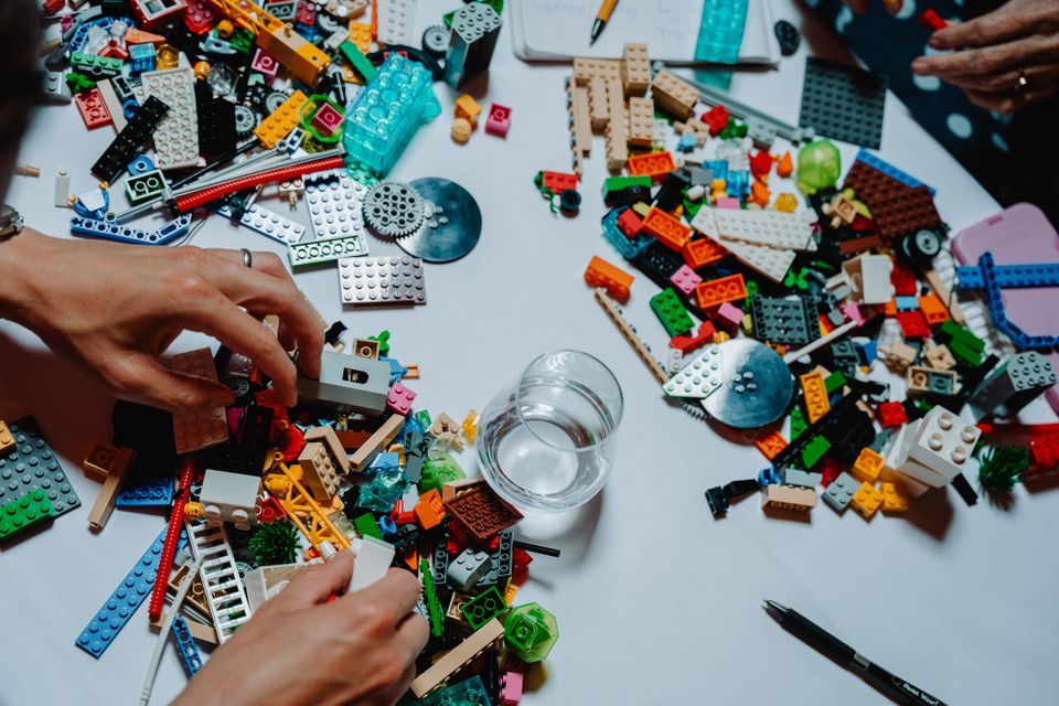 People around a table with lego pieces scattered around