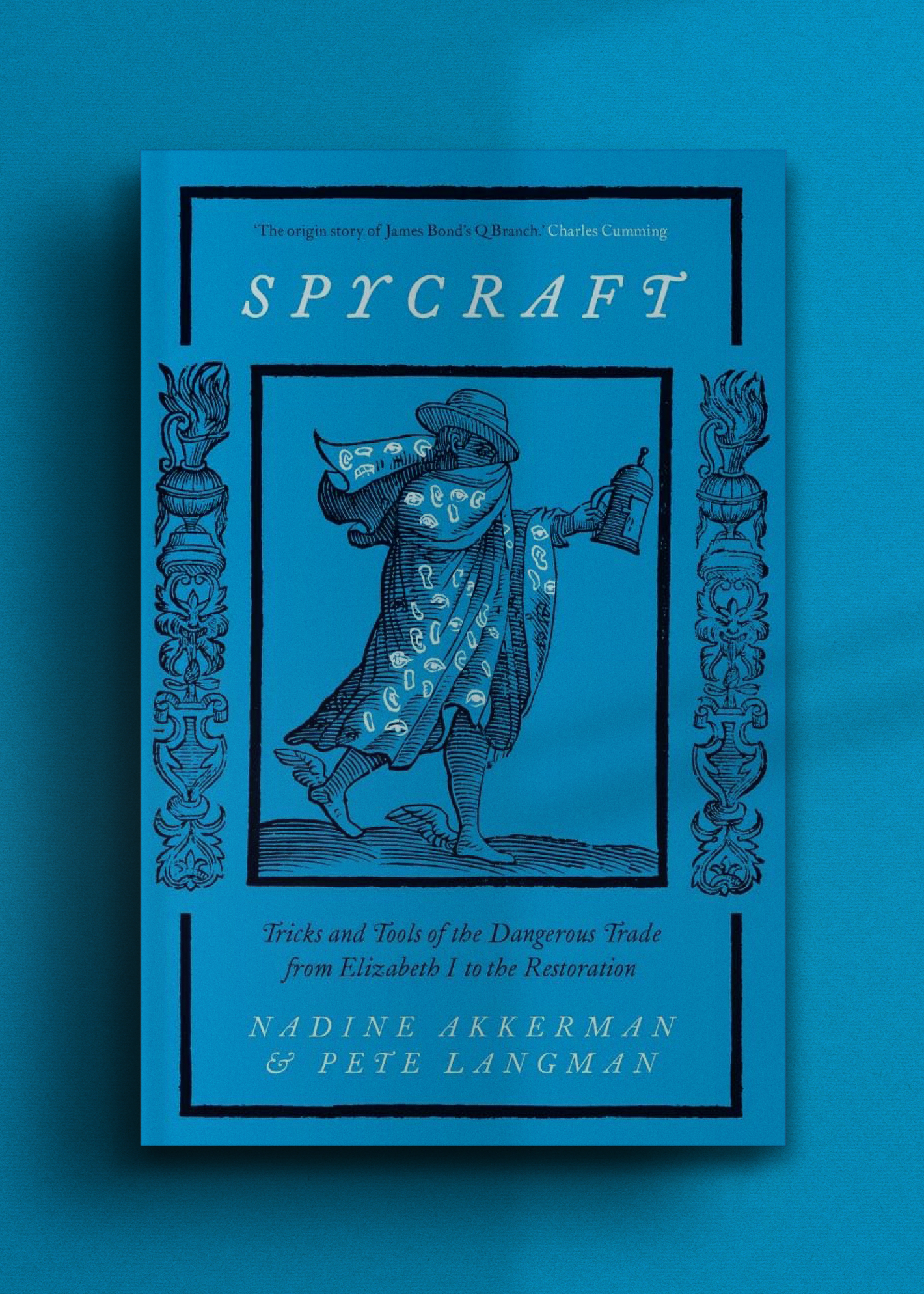 Blue book cover titled "Spycraft" by Nadine Akkerman & Pete Langman. Features a etched illustration of a mysterious figure in a cloak carrying a lantern.