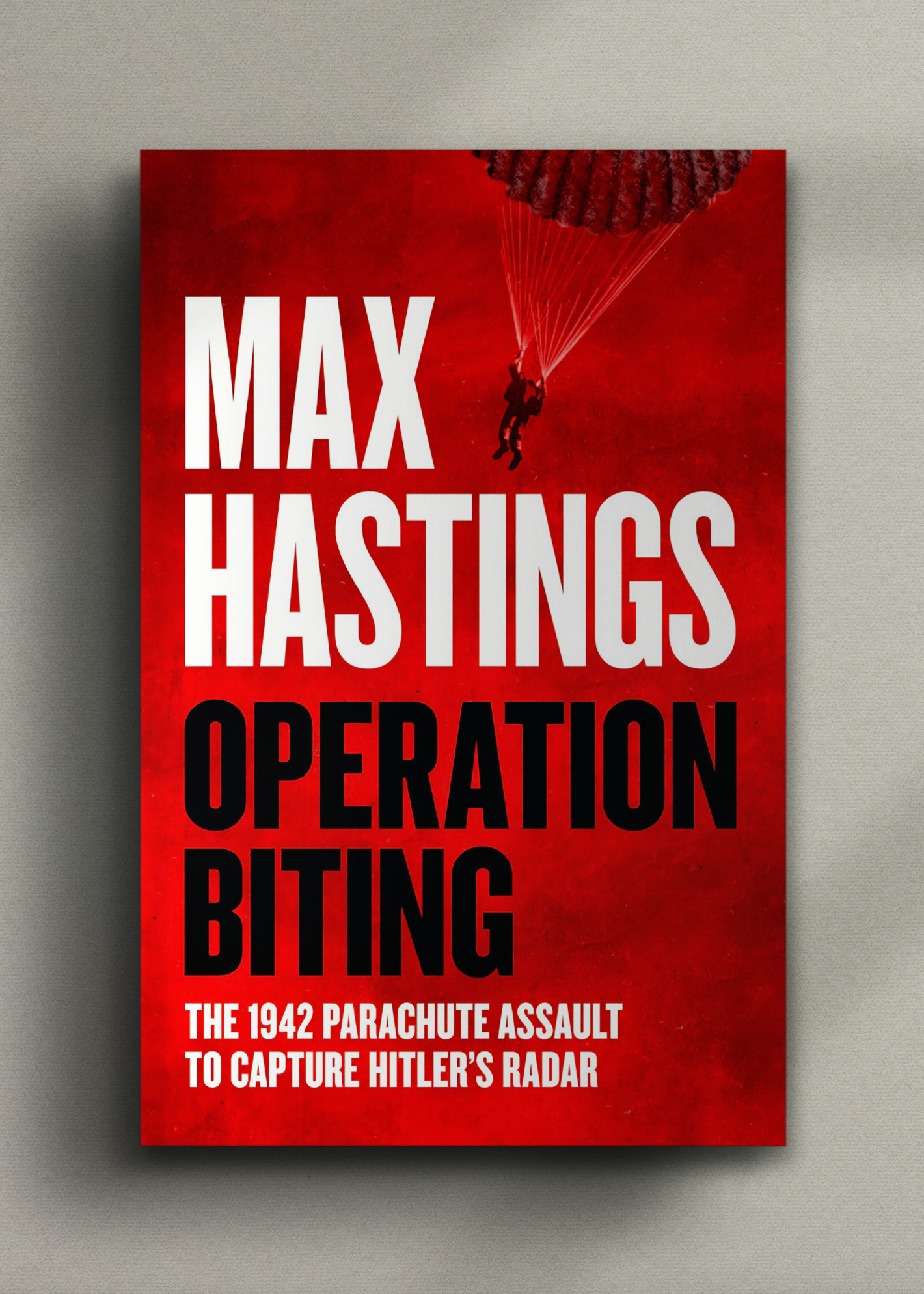 Cover of "Operation Biting" by Max Hastings. Bold text on red background, a parachutist silhouette descends. 
