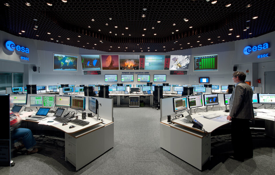 ESA Control Room with many screens on the desks and walls, alongside the ESA logo. 