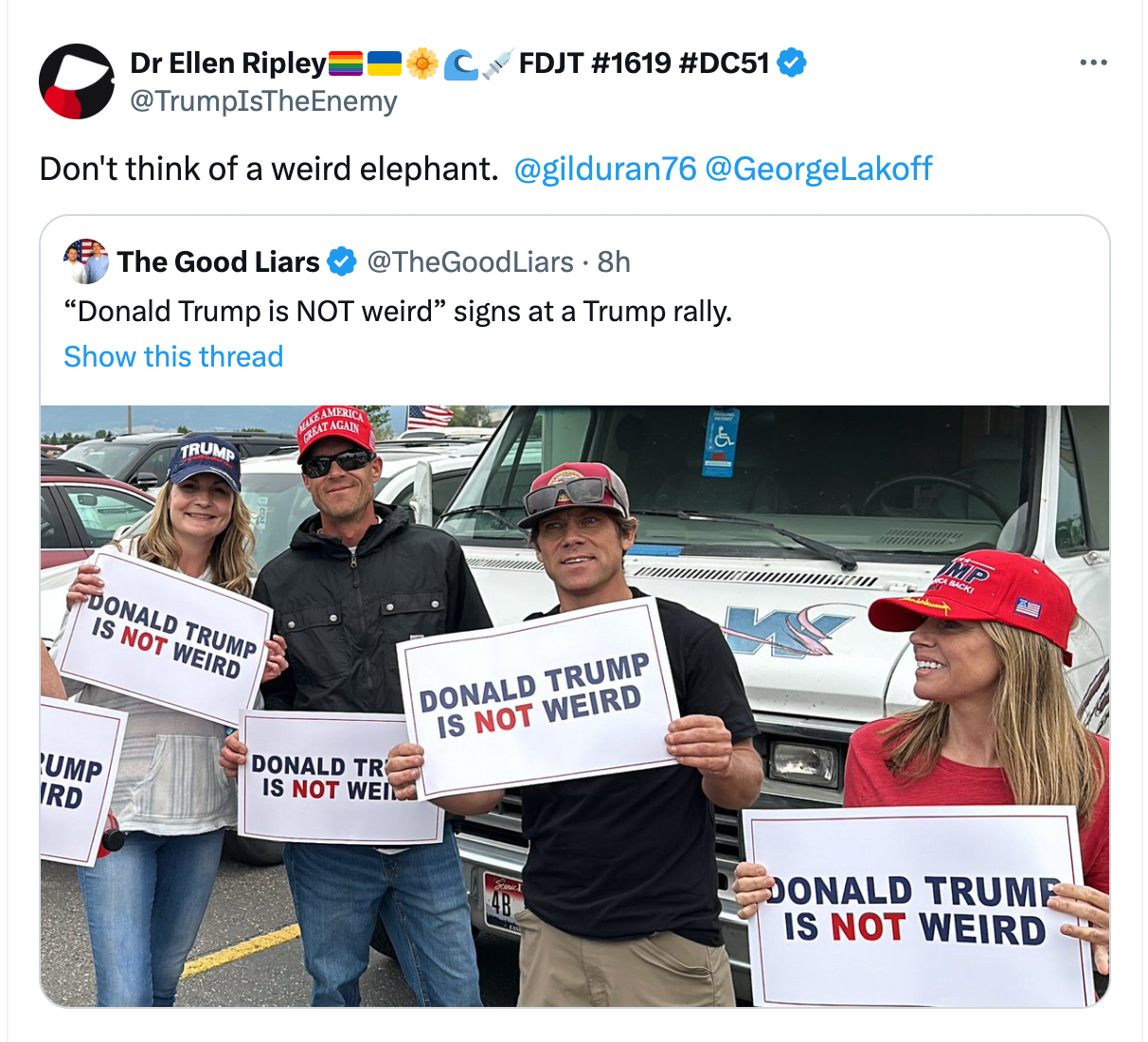 Trump fans holding "Trump is not weird" signs.