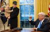 Photo of Elon Musk standing next to a seated Donald Trump in the Oval Office