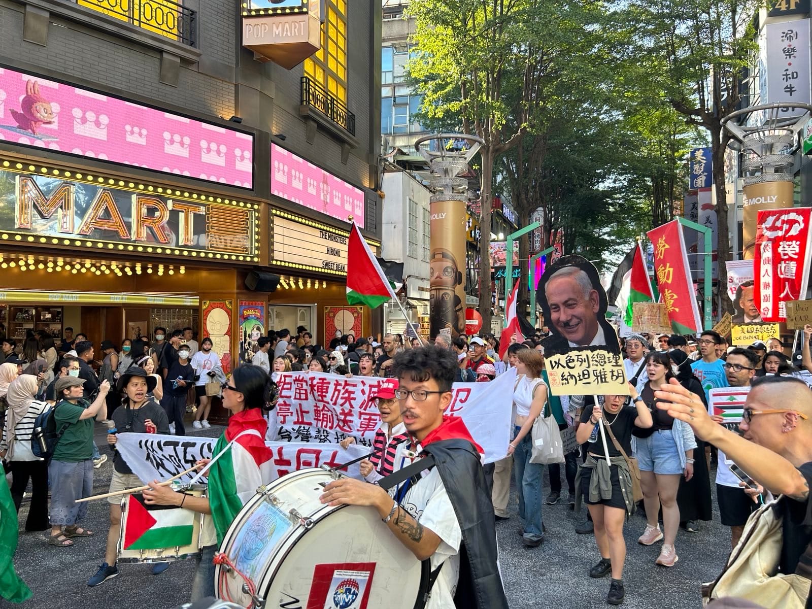 Young demonstrators in the streets of Taipei holding signs, banners and drums