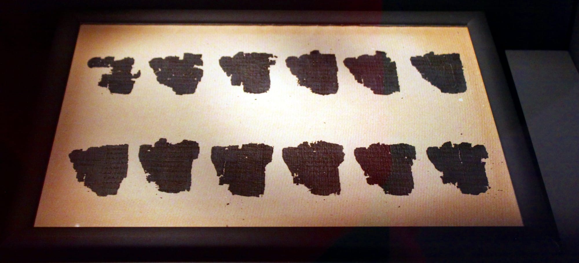 Fragments of the Derveni Papyrus displayed under glass in the Archaeological Museum of Thessaloniki