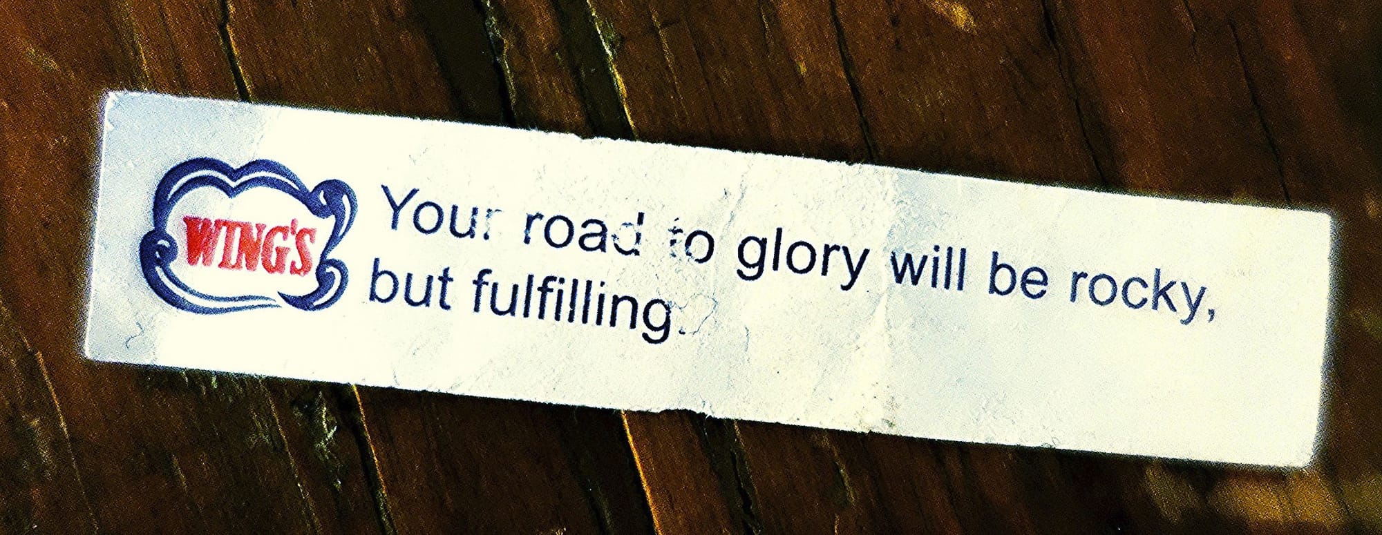 A fortune cookie fortune from Wing's, reading: Your road to glory will be rocky, but fulfilling