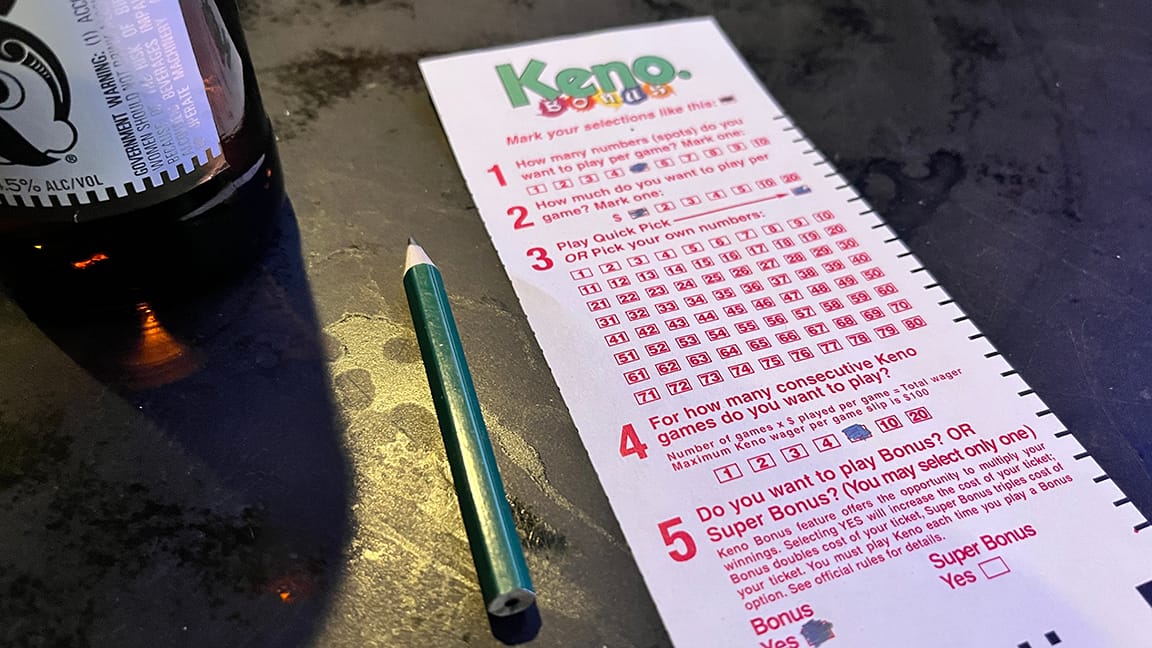 Keno card on a bar with tiny pencil and a beer.